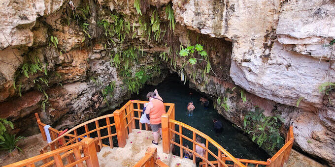 Refreshing cave swim in crystal clear water, surrounded by stunning rock formations and natural beauty, offering a serene and unique swimming experience in an underground cenote.