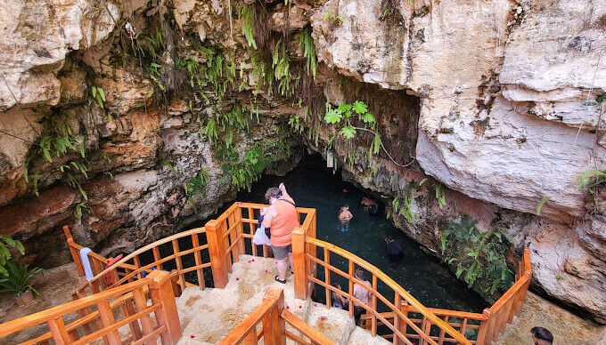 Refreshing cave swim in crystal clear water, surrounded by stunning rock formations and natural beauty, offering a serene and unique swimming experience in an underground cenote.