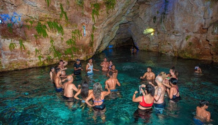 Refreshing cave swim in crystal clear water, surrounded by stunning rock formations and natural beauty, offering a serene and unique swimming experience in an underground cenote.