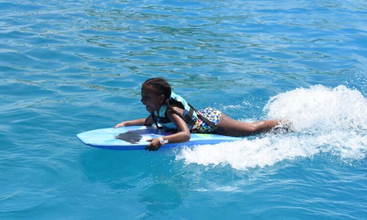 Memorable dolphin swim experience, with participants interacting closely with friendly dolphins in a controlled, shallow-water environment, enjoying the unique opportunity to swim, play, and bond with these intelligent marine animals