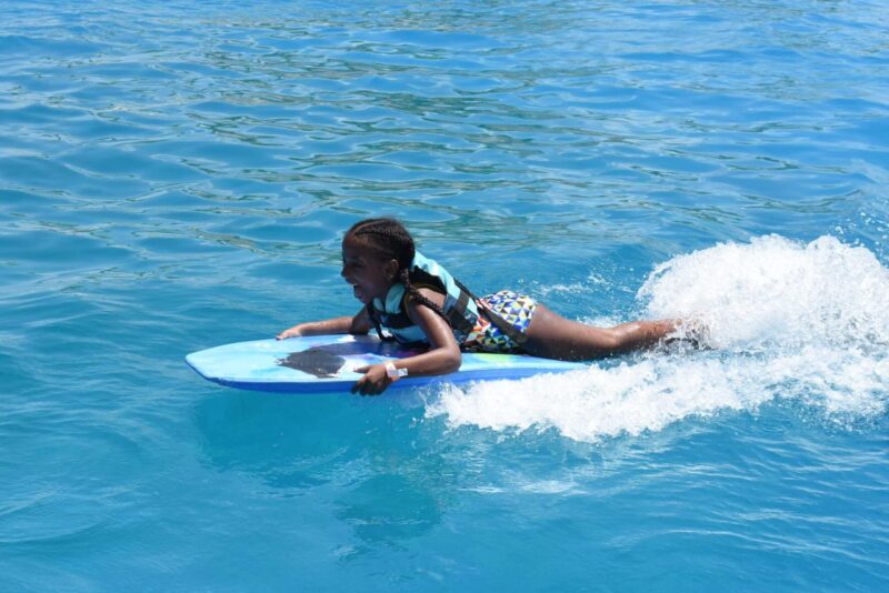 Memorable dolphin swim experience, with participants interacting closely with friendly dolphins in a controlled, shallow-water environment, enjoying the unique opportunity to swim, play, and bond with these intelligent marine animals