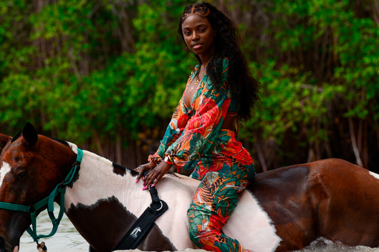 Scenic horse riding experience on the beach, with riders trotting along the shoreline, the gentle waves lapping at their feet, and the sun setting in the background, creating a tranquil and picturesque coastal adventure.