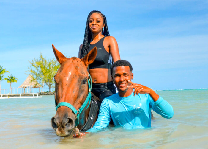 Scenic horse riding experience on the beach, with riders trotting along the shoreline, the gentle waves lapping at their feet, and the sun setting in the background, creating a tranquil and picturesque coastal adventure.