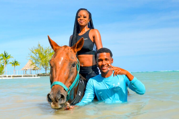 Scenic horse riding experience on the beach, with riders trotting along the shoreline, the gentle waves lapping at their feet, and the sun setting in the background, creating a tranquil and picturesque coastal adventure.