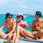 Vibrant party boat scene, with guests enjoying music, dancing, and refreshments on a lively boat deck, surrounded by open water and festive decorations, creating a fun and social atmosphere.