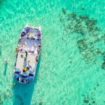 Vibrant party boat scene, with guests enjoying music, dancing, and refreshments on a lively boat deck, surrounded by open water and festive decorations, creating a fun and social atmosphere.