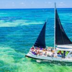 Vibrant party boat scene, with guests enjoying music, dancing, and refreshments on a lively boat deck, surrounded by open water and festive decorations, creating a fun and social atmosphere.