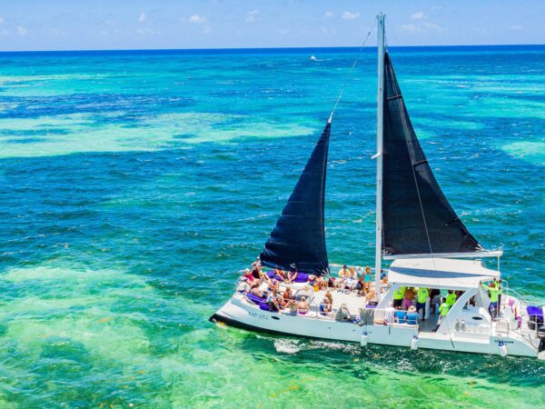 Vibrant party boat scene, with guests enjoying music, dancing, and refreshments on a lively boat deck, surrounded by open water and festive decorations, creating a fun and social atmosphere.