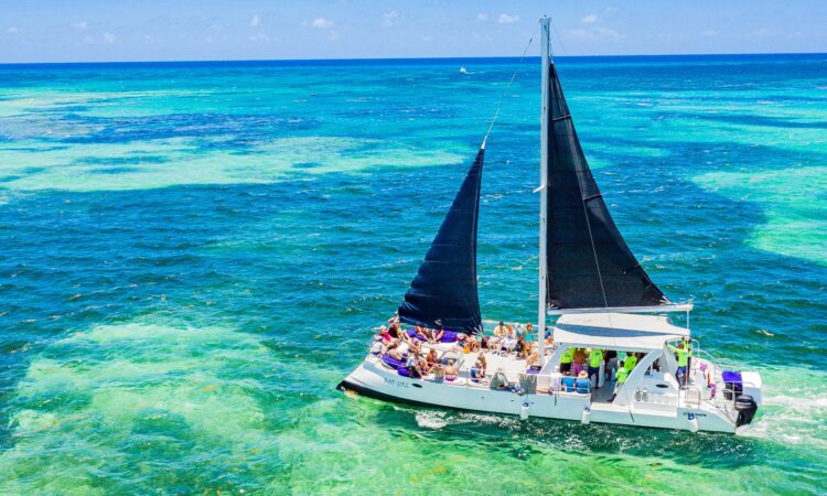 Vibrant party boat scene, with guests enjoying music, dancing, and refreshments on a lively boat deck, surrounded by open water and festive decorations, creating a fun and social atmosphere.