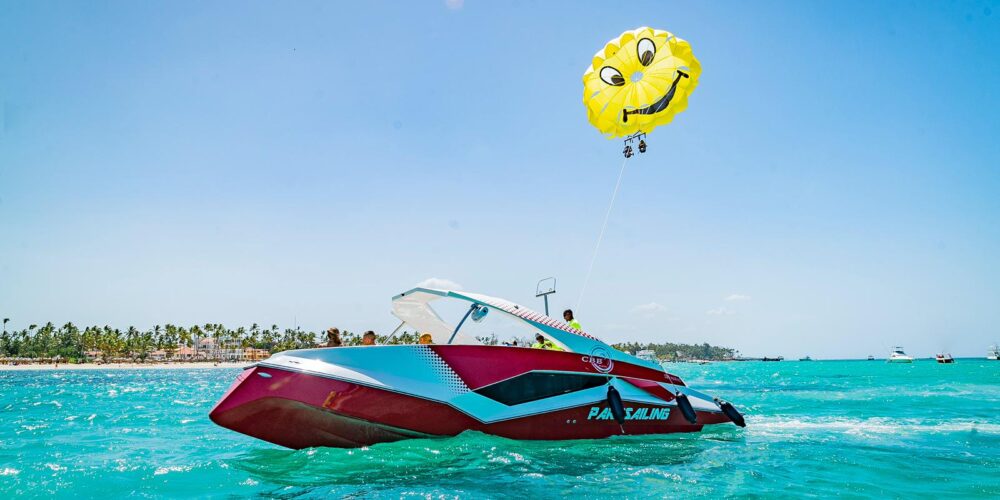 Thrilling parasailing experience, with individuals soaring high above the water while securely harnessed to a colorful parachute, enjoying breathtaking aerial views and the excitement of gliding over the ocean.