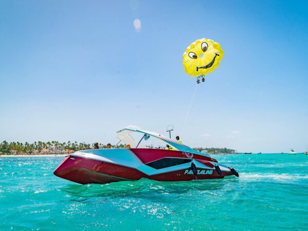 Thrilling parasailing experience, with individuals soaring high above the water while securely harnessed to a colorful parachute, enjoying breathtaking aerial views and the excitement of gliding over the ocean.