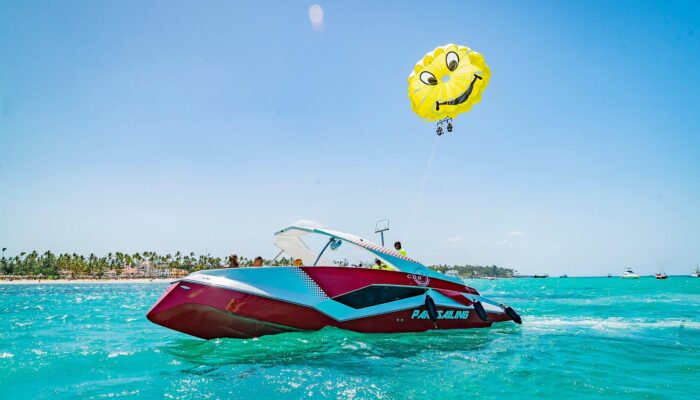 Thrilling parasailing experience, with individuals soaring high above the water while securely harnessed to a colorful parachute, enjoying breathtaking aerial views and the excitement of gliding over the ocean.