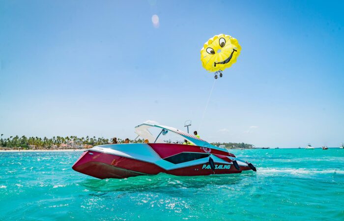Thrilling parasailing experience, with individuals soaring high above the water while securely harnessed to a colorful parachute, enjoying breathtaking aerial views and the excitement of gliding over the ocean.