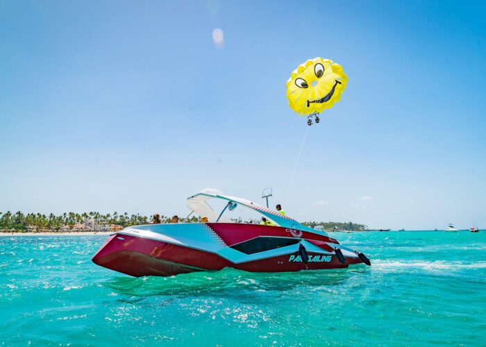 Thrilling parasailing experience, with individuals soaring high above the water while securely harnessed to a colorful parachute, enjoying breathtaking aerial views and the excitement of gliding over the ocean.