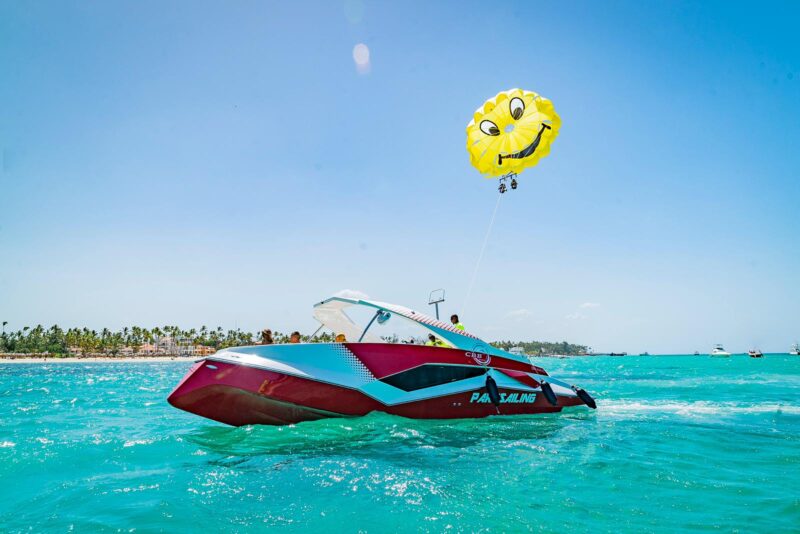 Thrilling parasailing experience, with individuals soaring high above the water while securely harnessed to a colorful parachute, enjoying breathtaking aerial views and the excitement of gliding over the ocean.