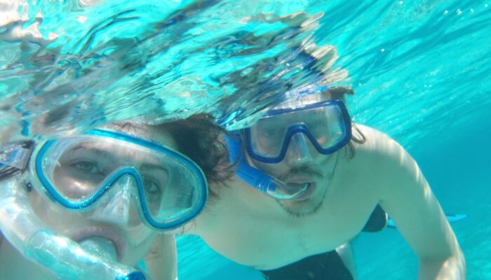 Participants snorkeling in clear, turquoise waters, wearing masks and snorkels to explore vibrant coral reefs and colorful marine life, enjoying an underwater adventure in a tropical setting.