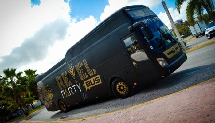 Fun-filled party bus interior, featuring vibrant lighting, comfortable seating, and music, with guests dancing and enjoying themselves while traveling to various destinations in a lively and festive atmosphere