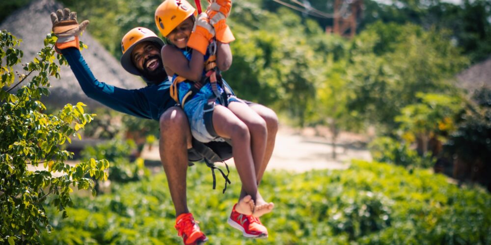 Participants ziplining through treetops with panoramic views of lush landscapes.