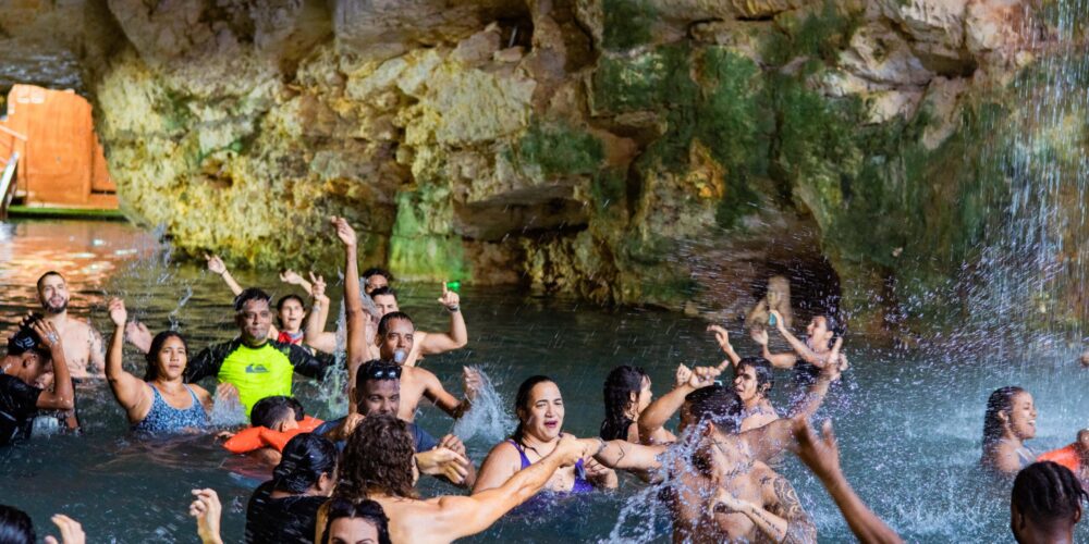 Refreshing cave swim in crystal clear water, surrounded by stunning rock formations and natural beauty, offering a serene and unique swimming experience in an underground cenote.