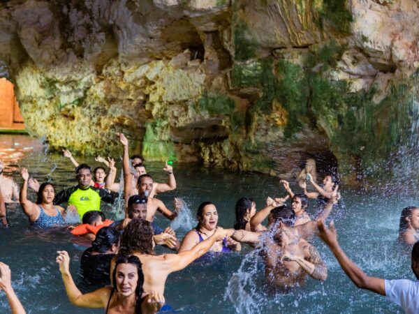 Refreshing cave swim in crystal clear water, surrounded by stunning rock formations and natural beauty, offering a serene and unique swimming experience in an underground cenote.