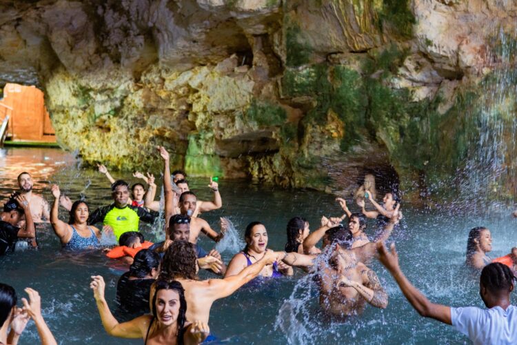 Refreshing cave swim in crystal clear water, surrounded by stunning rock formations and natural beauty, offering a serene and unique swimming experience in an underground cenote.