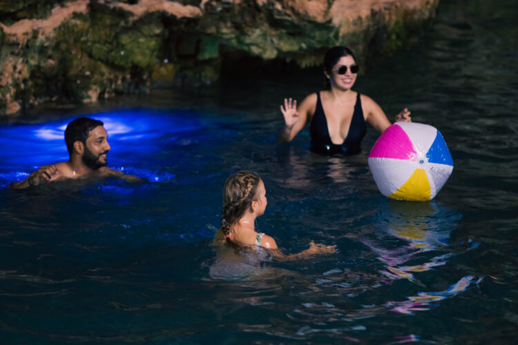 Refreshing cave swim in crystal clear water, surrounded by stunning rock formations and natural beauty, offering a serene and unique swimming experience in an underground cenote.