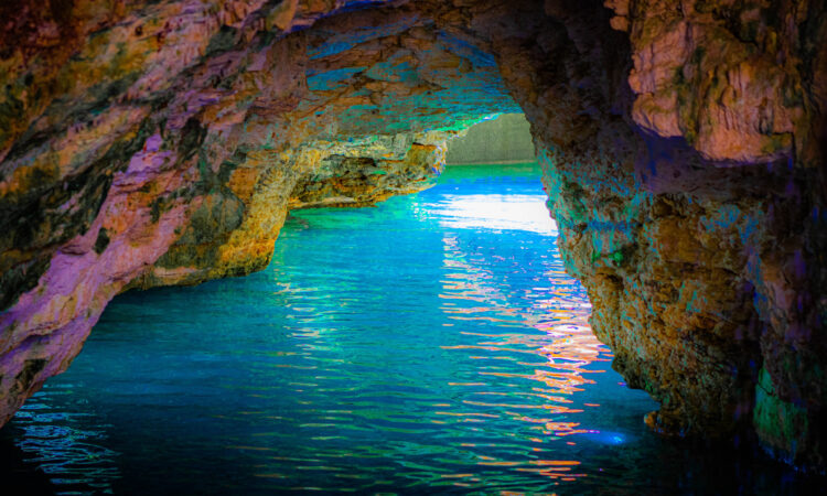 Refreshing cave swim in crystal clear water, surrounded by stunning rock formations and natural beauty, offering a serene and unique swimming experience in an underground cenote.