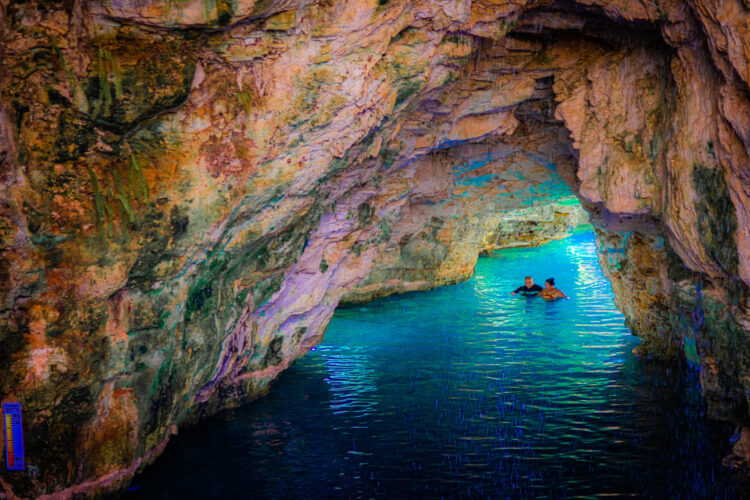 Refreshing cave swim in crystal clear water, surrounded by stunning rock formations and natural beauty, offering a serene and unique swimming experience in an underground cenote.