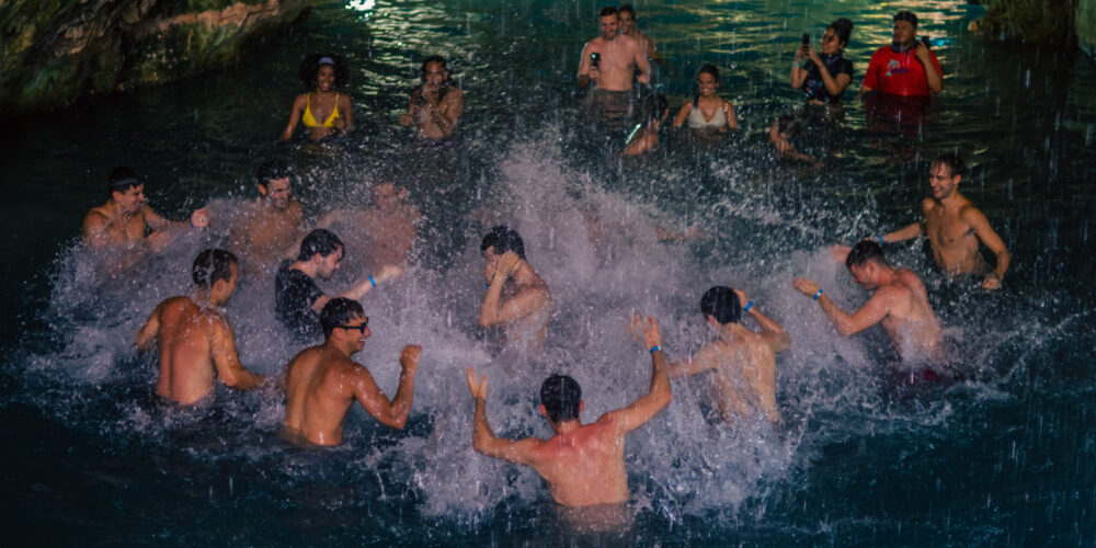 Refreshing cave swim in crystal clear water, surrounded by stunning rock formations and natural beauty, offering a serene and unique swimming experience in an underground cenote.