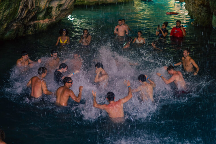 Refreshing cave swim in crystal clear water, surrounded by stunning rock formations and natural beauty, offering a serene and unique swimming experience in an underground cenote.