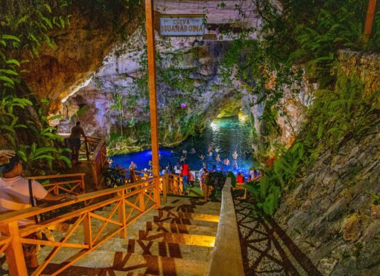 Refreshing cave swim in crystal clear water, surrounded by stunning rock formations and natural beauty, offering a serene and unique swimming experience in an underground cenote.