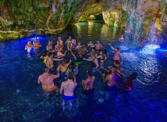 Refreshing cave swim in crystal clear water, surrounded by stunning rock formations and natural beauty, offering a serene and unique swimming experience in an underground cenote.